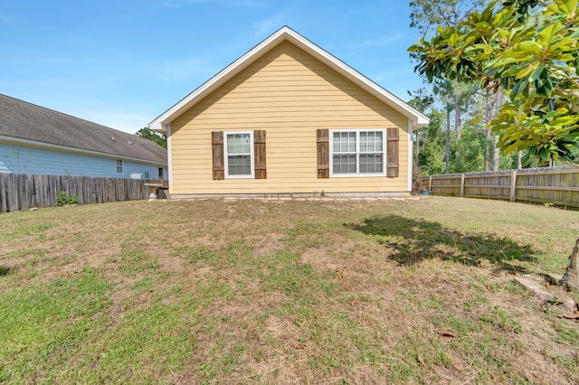 rear view of house featuring a yard