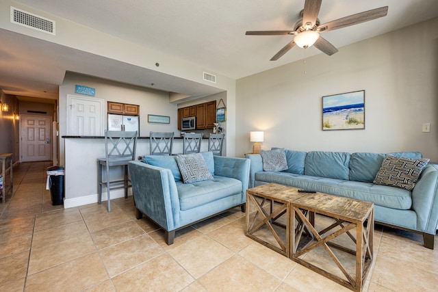 living room with ceiling fan and light tile patterned flooring