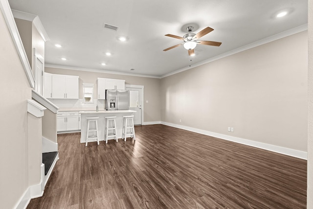 unfurnished living room with sink, ceiling fan, ornamental molding, and dark hardwood / wood-style flooring