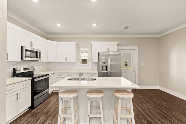 kitchen featuring appliances with stainless steel finishes, white cabinets, a kitchen island with sink, and sink