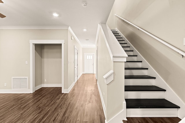 stairway featuring ornamental molding and hardwood / wood-style floors