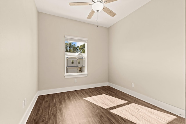 spare room featuring dark wood-type flooring and ceiling fan