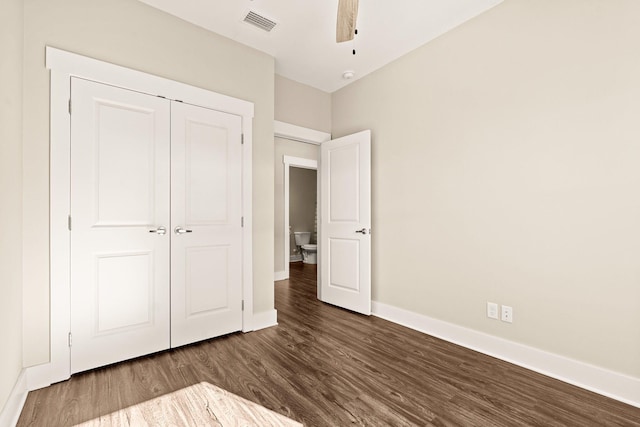 unfurnished bedroom featuring a closet, ceiling fan, and dark hardwood / wood-style flooring