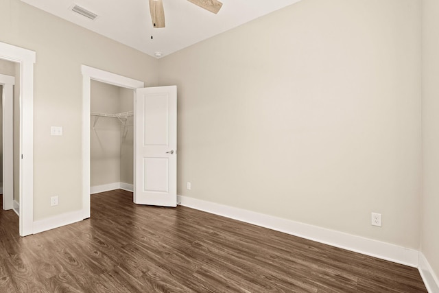 unfurnished bedroom with dark wood-type flooring, a closet, and ceiling fan