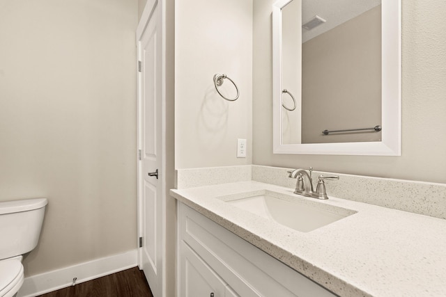 bathroom featuring vanity, hardwood / wood-style flooring, and toilet