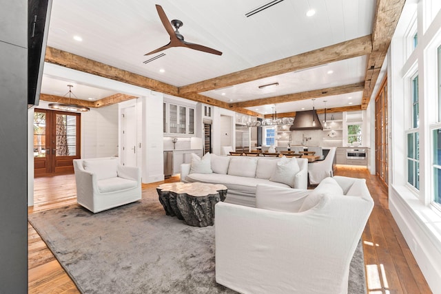 living room with french doors, beam ceiling, light hardwood / wood-style flooring, and ceiling fan