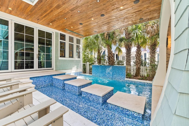 view of pool with pool water feature, a patio, and ceiling fan