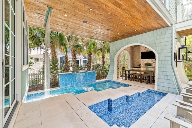 view of swimming pool featuring pool water feature and a patio