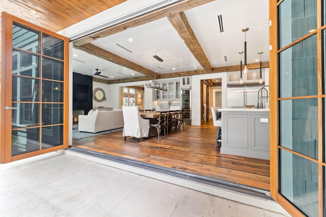 interior space featuring light hardwood / wood-style flooring, beam ceiling, and ceiling fan