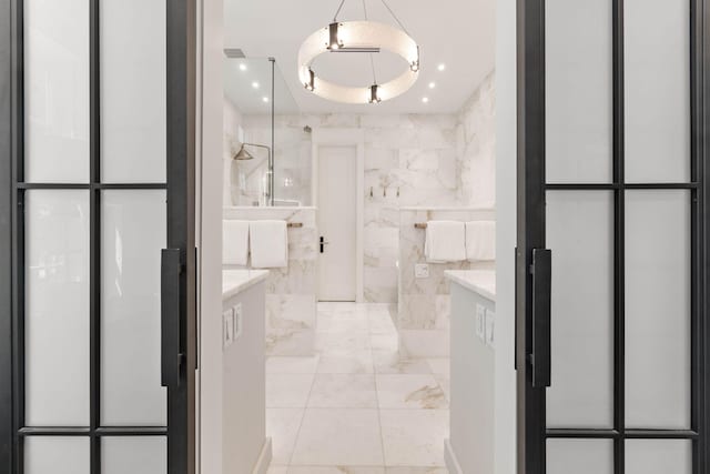 bathroom with vanity, a shower, and tile walls