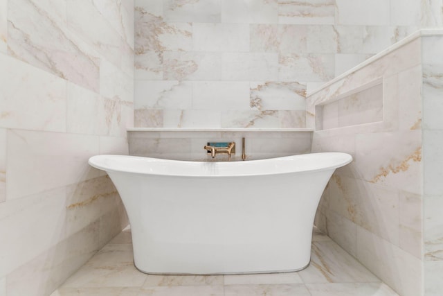 bathroom with a tub and tile walls