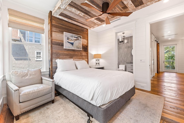 bedroom featuring hardwood / wood-style floors, wooden walls, and ceiling fan