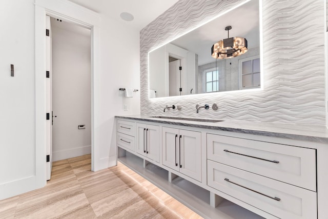 bathroom featuring vanity, a chandelier, hardwood / wood-style flooring, and backsplash