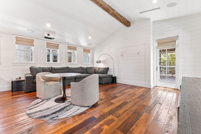 living room with dark wood-type flooring, lofted ceiling with beams, and wooden walls