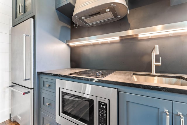 kitchen featuring stainless steel appliances, sink, and blue cabinets