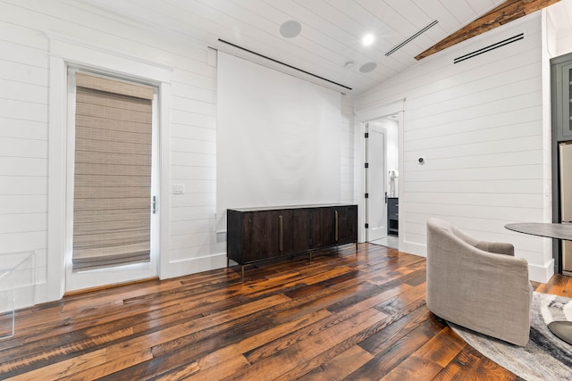 living area featuring wooden walls, dark wood-type flooring, and vaulted ceiling