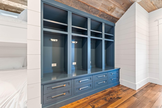 mudroom with wood walls, dark hardwood / wood-style floors, wooden ceiling, and vaulted ceiling