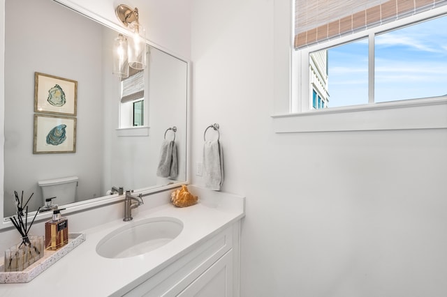 bathroom with vanity, toilet, and plenty of natural light