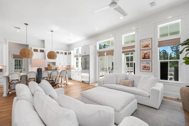 living room featuring light hardwood / wood-style flooring and ceiling fan