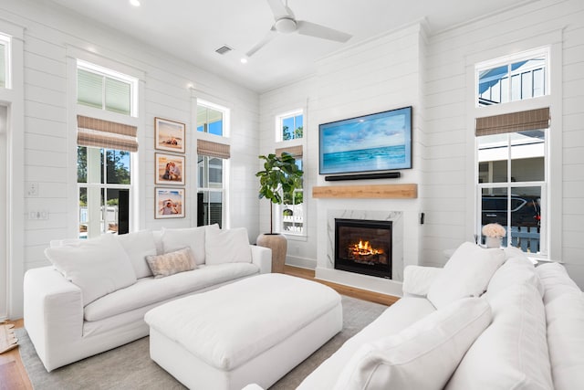 living room featuring hardwood / wood-style floors, a large fireplace, and ceiling fan