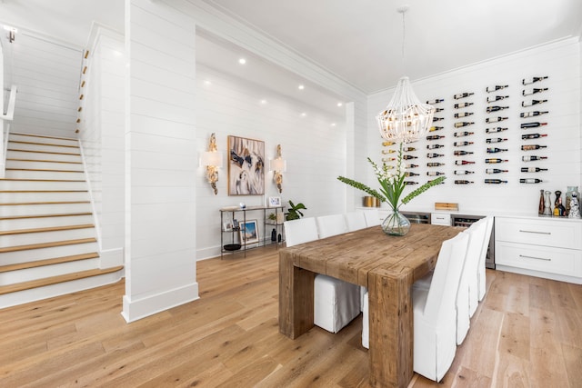 dining space featuring light hardwood / wood-style floors, an inviting chandelier, and crown molding