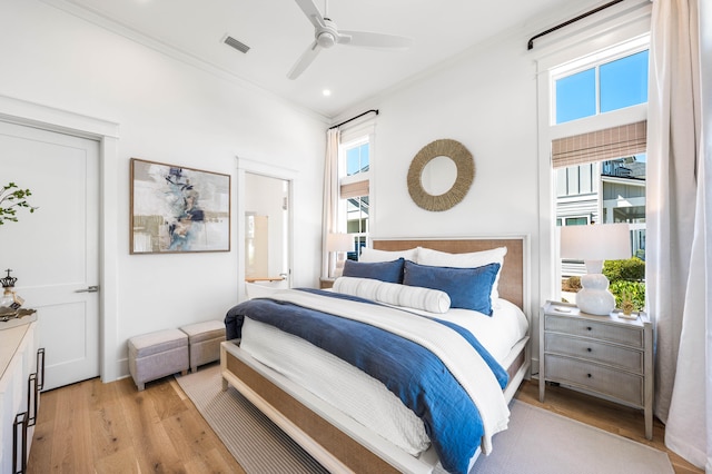 bedroom with light hardwood / wood-style flooring, ornamental molding, ensuite bath, and ceiling fan