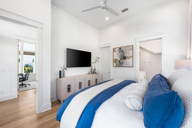 bedroom featuring ceiling fan, crown molding, and light hardwood / wood-style flooring