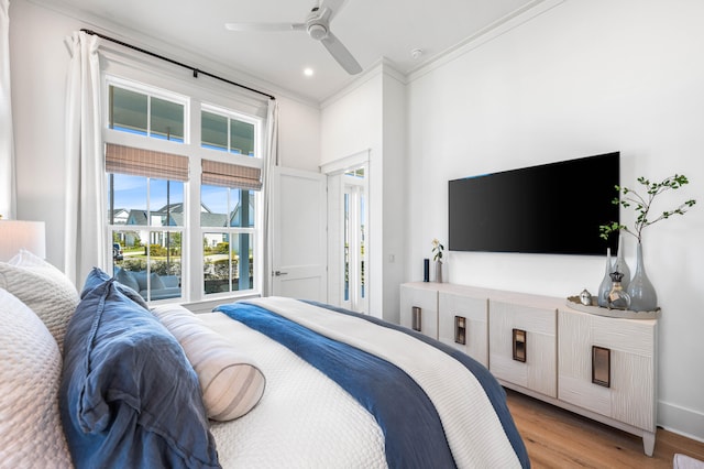 bedroom featuring crown molding, light hardwood / wood-style flooring, and ceiling fan