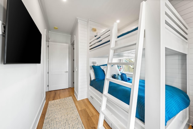 bedroom featuring crown molding and light hardwood / wood-style flooring