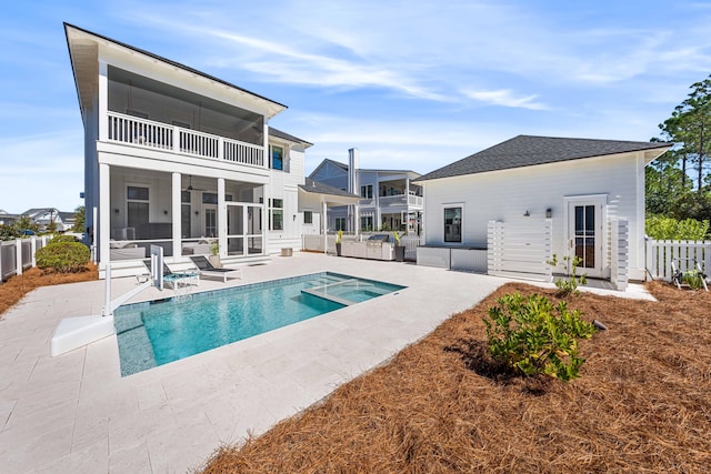 back of house with a fenced in pool, a patio, and a balcony