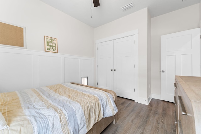 bedroom with dark hardwood / wood-style floors, a closet, and ceiling fan