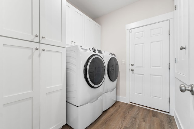 laundry area with washer and dryer, cabinets, and dark hardwood / wood-style flooring