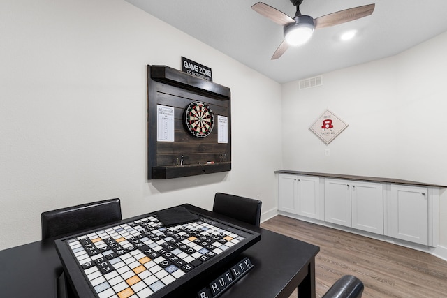 dining space with ceiling fan and light hardwood / wood-style flooring