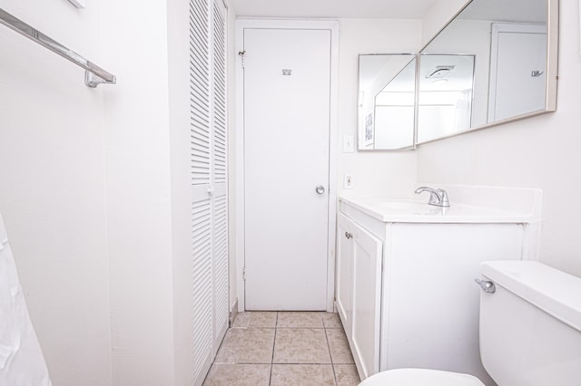 bathroom featuring tile patterned flooring, vanity, and toilet