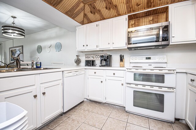 kitchen featuring pendant lighting, sink, white cabinets, light tile patterned floors, and white appliances