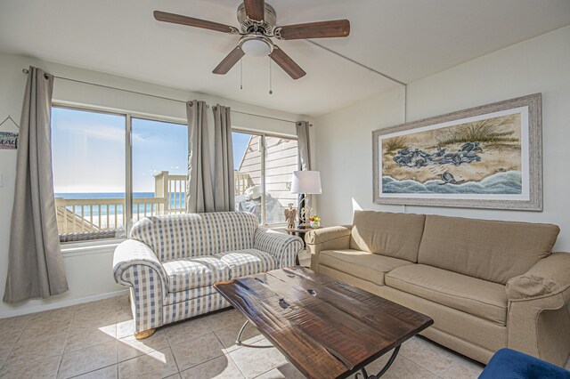 living room with a water view, ceiling fan, plenty of natural light, and light tile patterned flooring