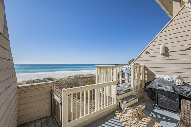 exterior space featuring grilling area, a beach view, and a water view