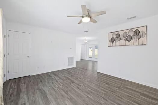 empty room with dark hardwood / wood-style floors and ceiling fan