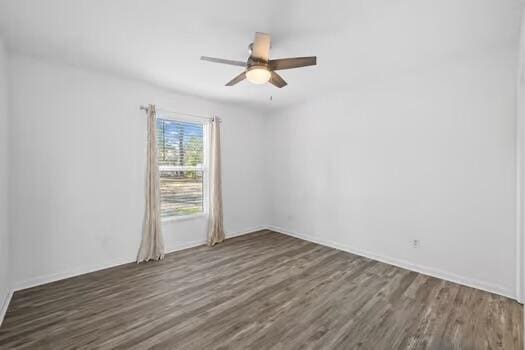 spare room with ceiling fan and dark hardwood / wood-style flooring