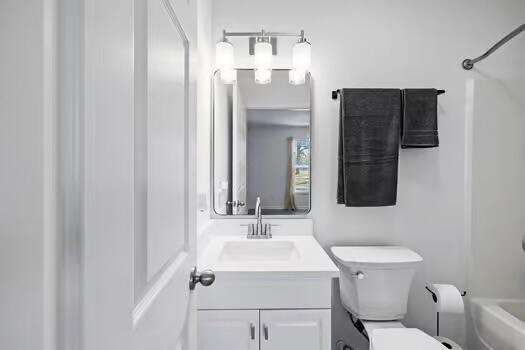 full bathroom featuring toilet, vanity, and bathing tub / shower combination