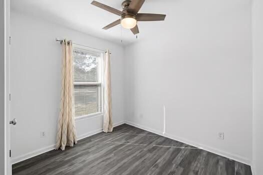 unfurnished room featuring dark wood-type flooring and ceiling fan