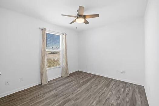 empty room with dark wood-type flooring and ceiling fan