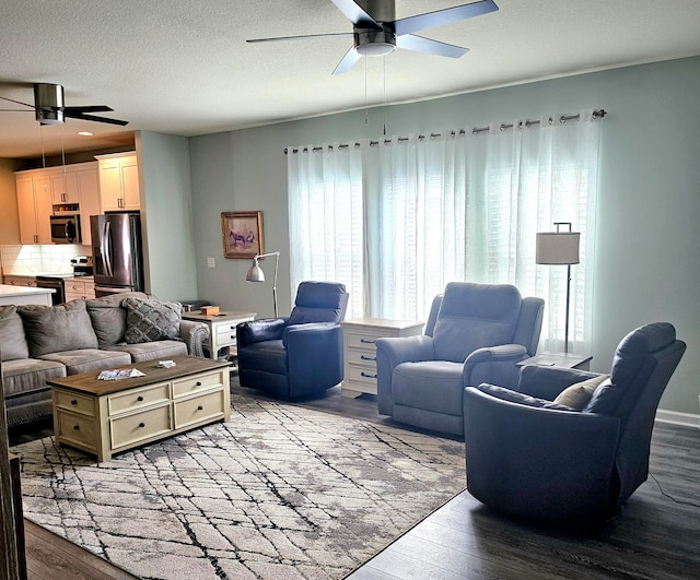 living room with light hardwood / wood-style floors, a textured ceiling, and ceiling fan