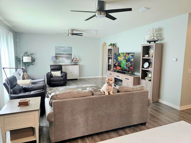 living room featuring ceiling fan and dark hardwood / wood-style flooring