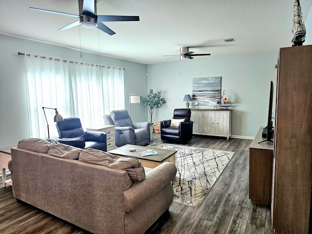 living room featuring a textured ceiling, dark hardwood / wood-style floors, and ceiling fan