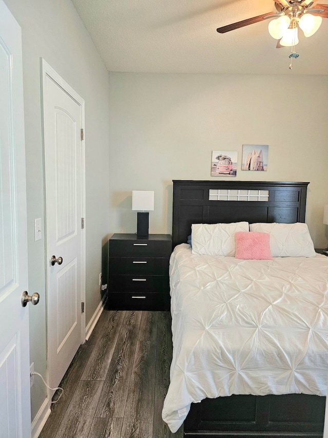 bedroom featuring dark wood-type flooring, ceiling fan, and a textured ceiling