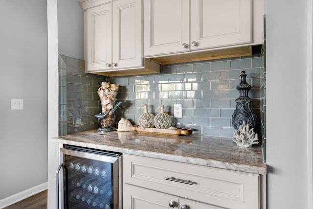bar featuring dark wood-style floors, wine cooler, baseboards, and tasteful backsplash