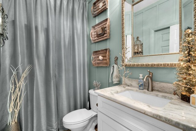 bathroom with toilet, curtained shower, and vanity