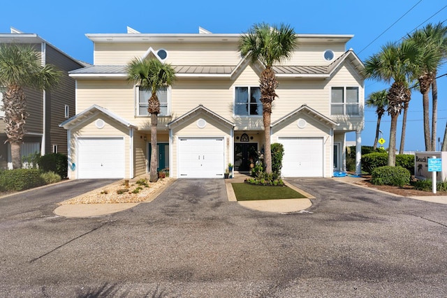view of front of property with driveway, metal roof, and a garage