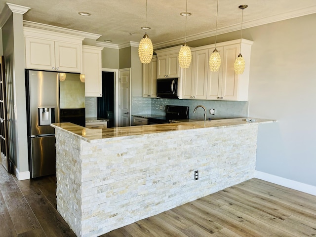kitchen with tasteful backsplash, black appliances, a peninsula, baseboards, and ornamental molding